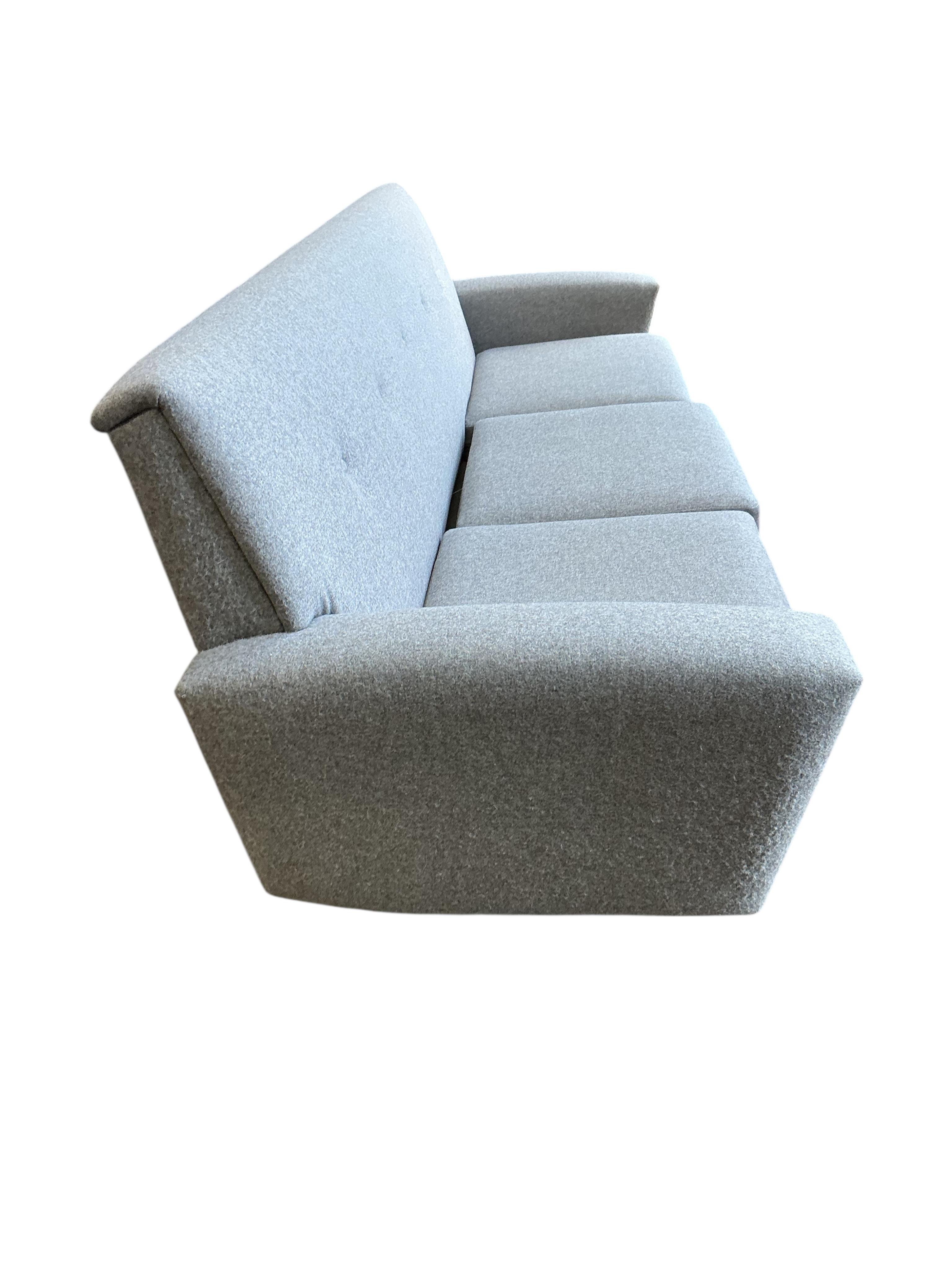 In the manner of Georg Thams, a Danish style mid century design three seater settee upholstered in grey wool fabric, width 214cm, depth 68cm, height 73cm